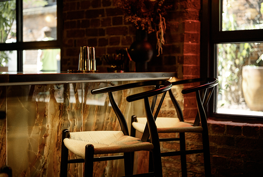 A lit bar setting tiled with onyx emerald polished porcelain wall tiles